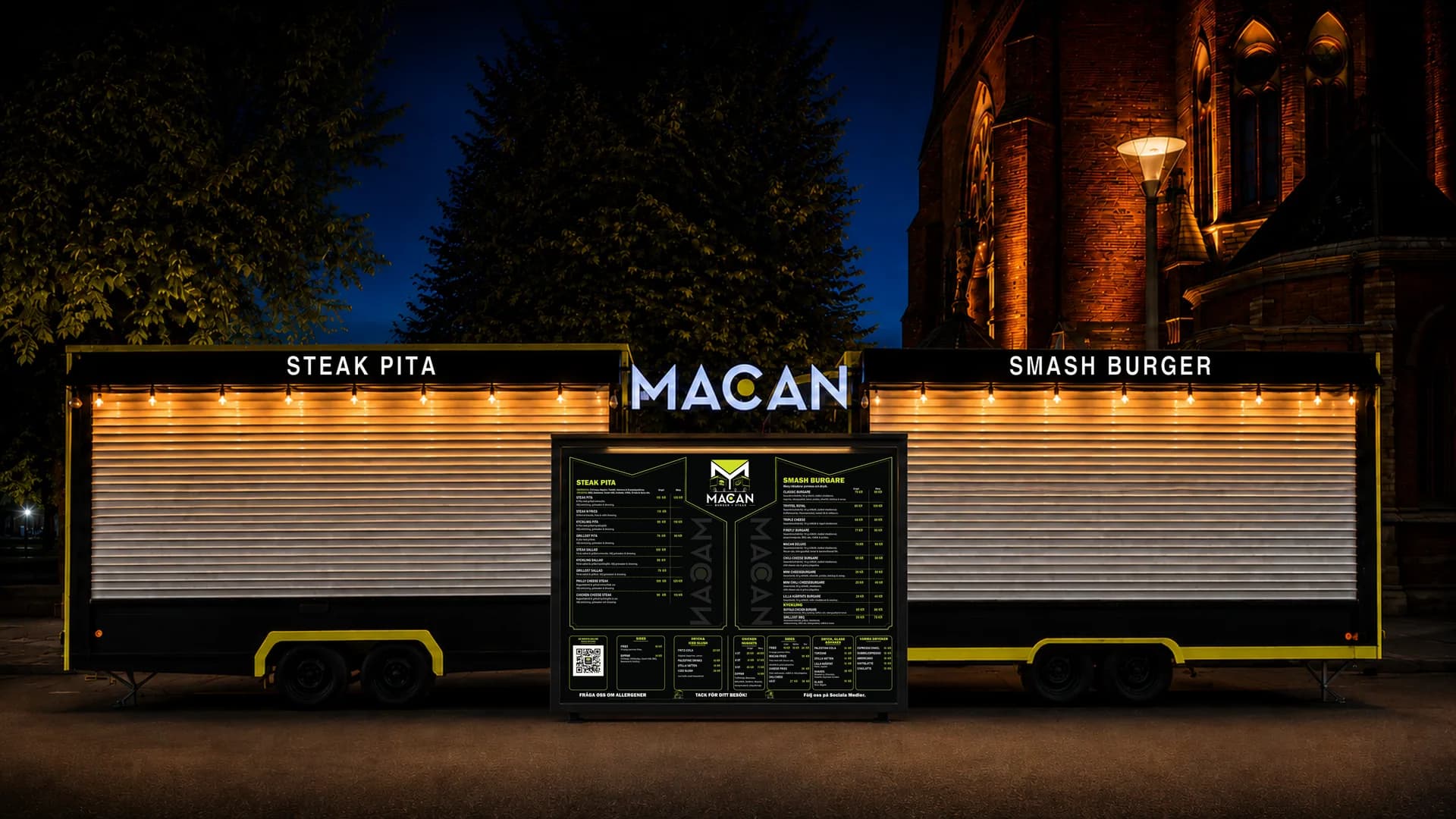 MACANs två food trucks sida vid sida en kväll i Helsingborg, upplysta, med menytavlan mellan sig.